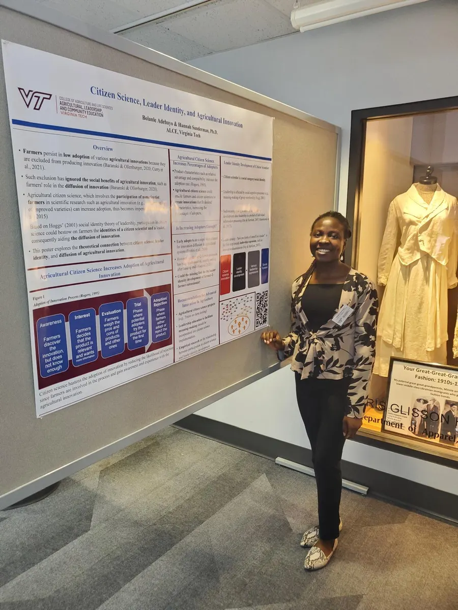 Bolanle Adebayo beside a research poster on citizen science, leader identity, and agricultural innovation